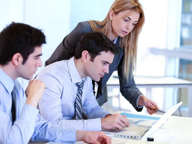 Two people working side by side at a computer