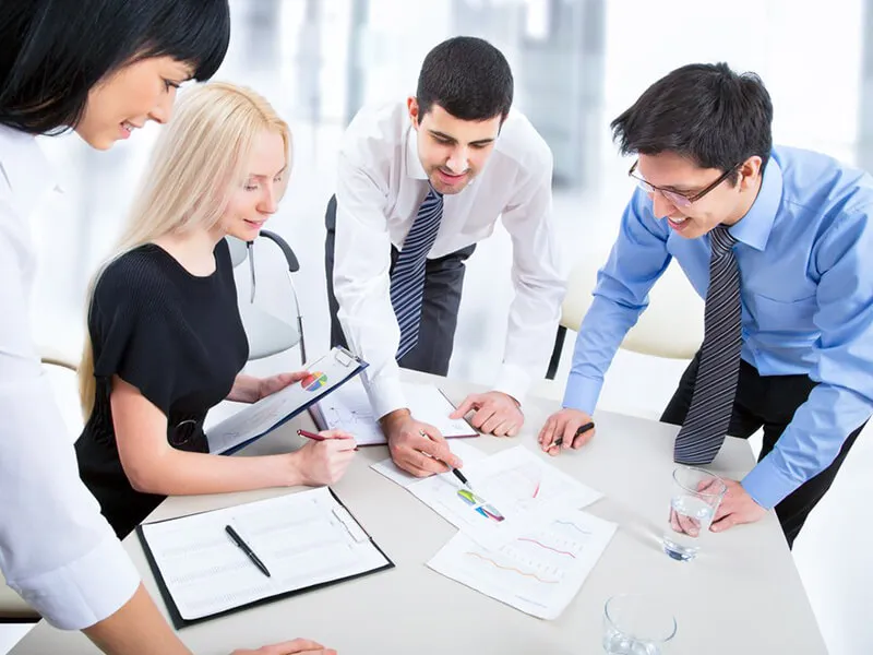 A small team working together around a laptop